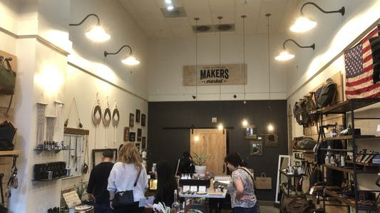 View inside Makers Market. Shopper in foreground looking at products